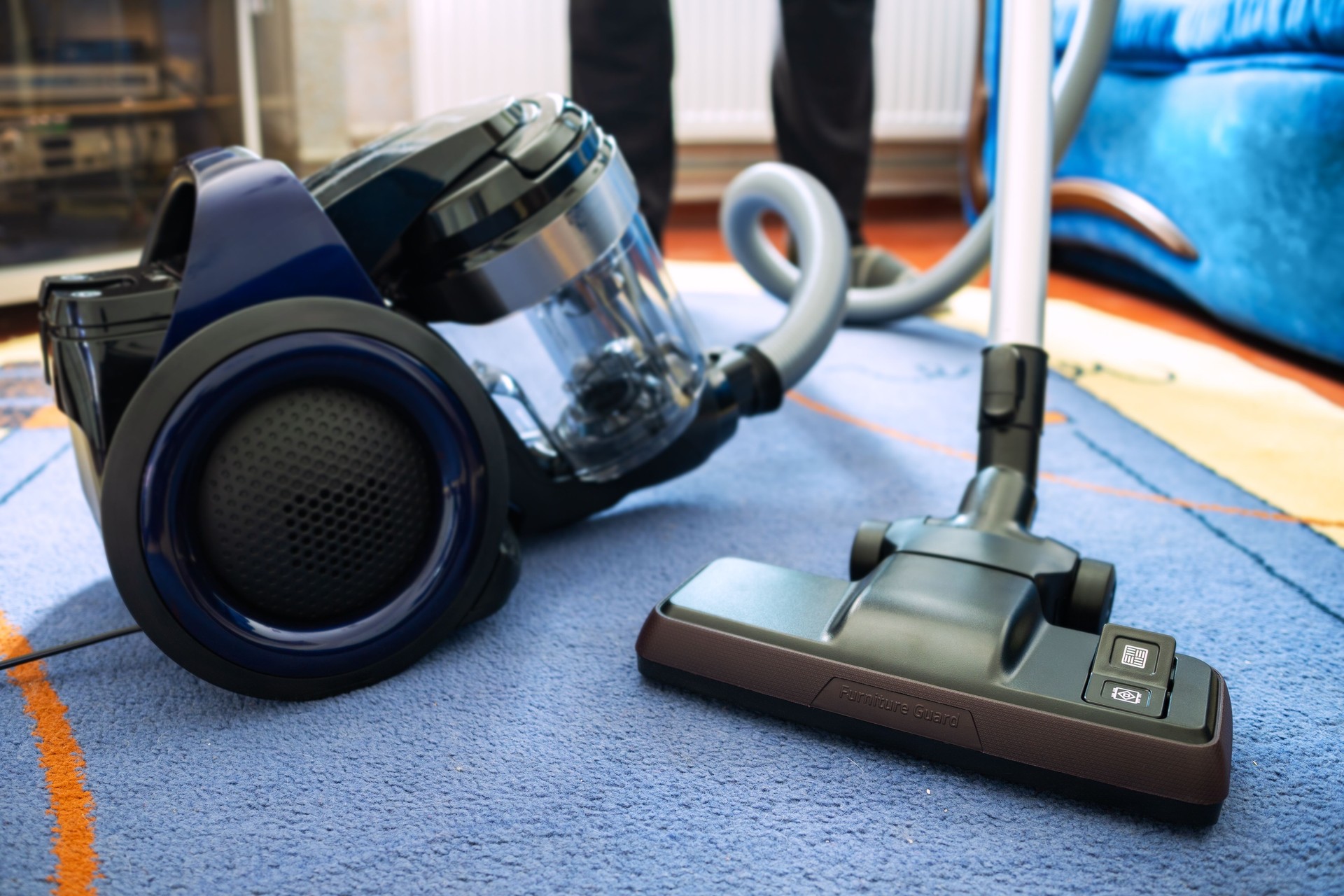 brush and vacuum cleaner near man on blurred background at home